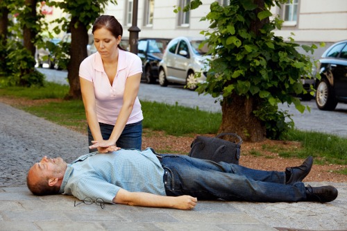 Provides first aid woman in a man with a heart attack in the street